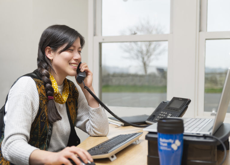 Support staff member answering phone to support people affected by Cystic Fibrosis in Scotland