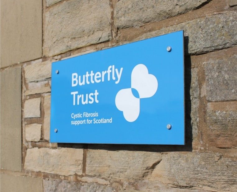 A Butterfly Trust sign attached to a stone wall.