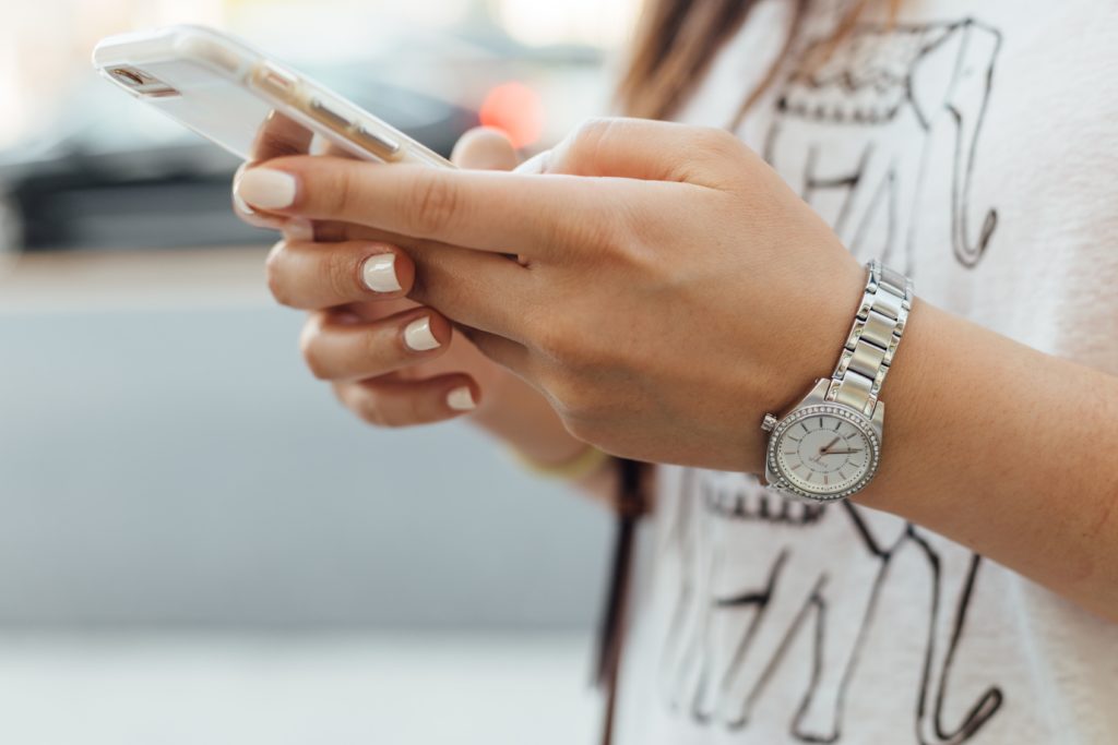 Someone holding a phone and making an online donation using the Butterfly Trust bank details.