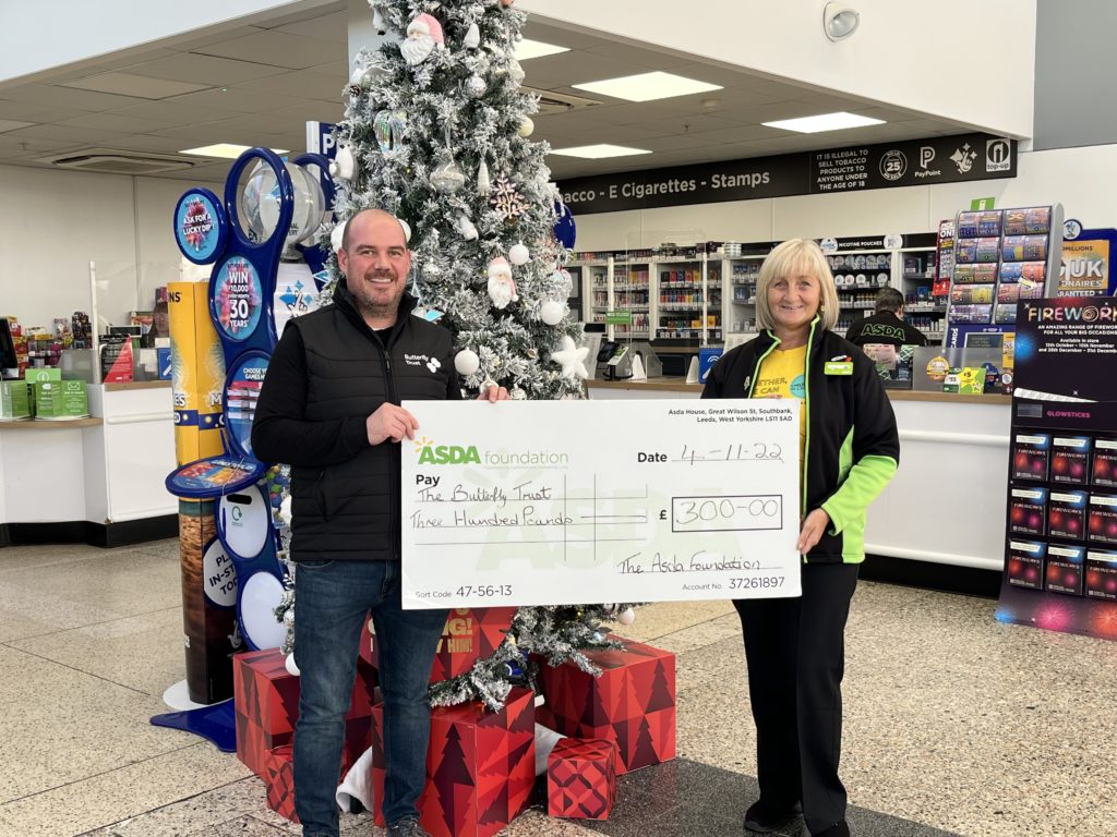 Butterfly Trust staff member receiving a cheque donation from an Asda staff member.