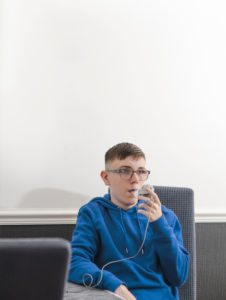 A young man using a PEP mask for physiotherapy.